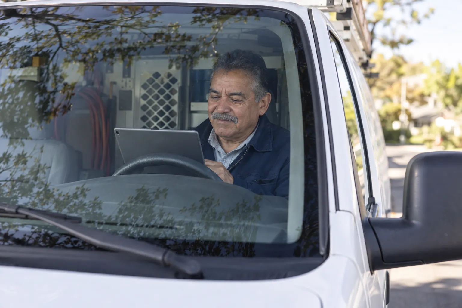 Illustrative scene: a service-business owner checking the day’s schedule from the work van